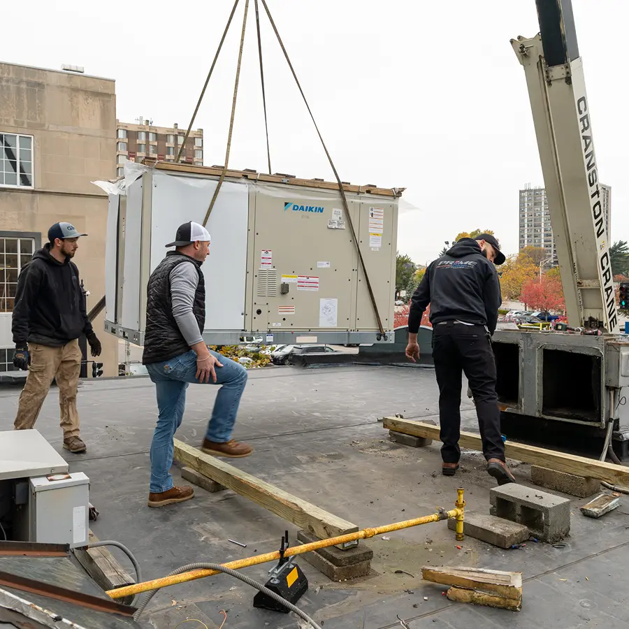 Installing HVAC unit on rooftop in Providence Rhode Island by Prime Heating & Cooling