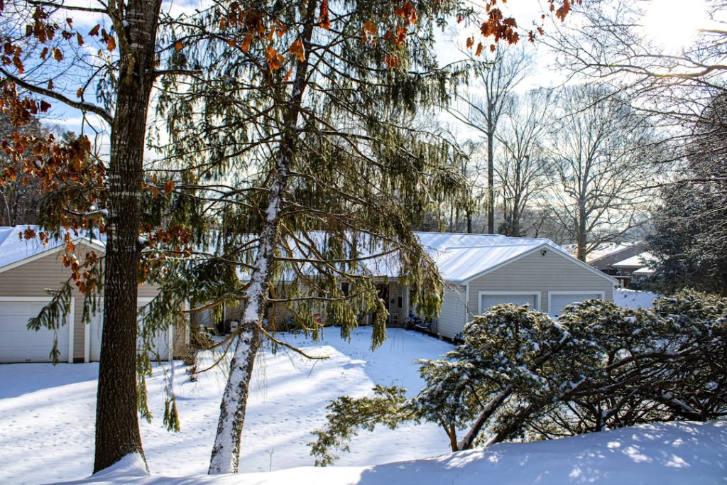 Emergency heating service RI snow-covered home at dusk - Emergency heating service RI